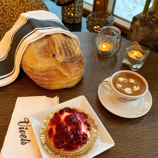 Ett bord md cappuccino, bakelse och bröd